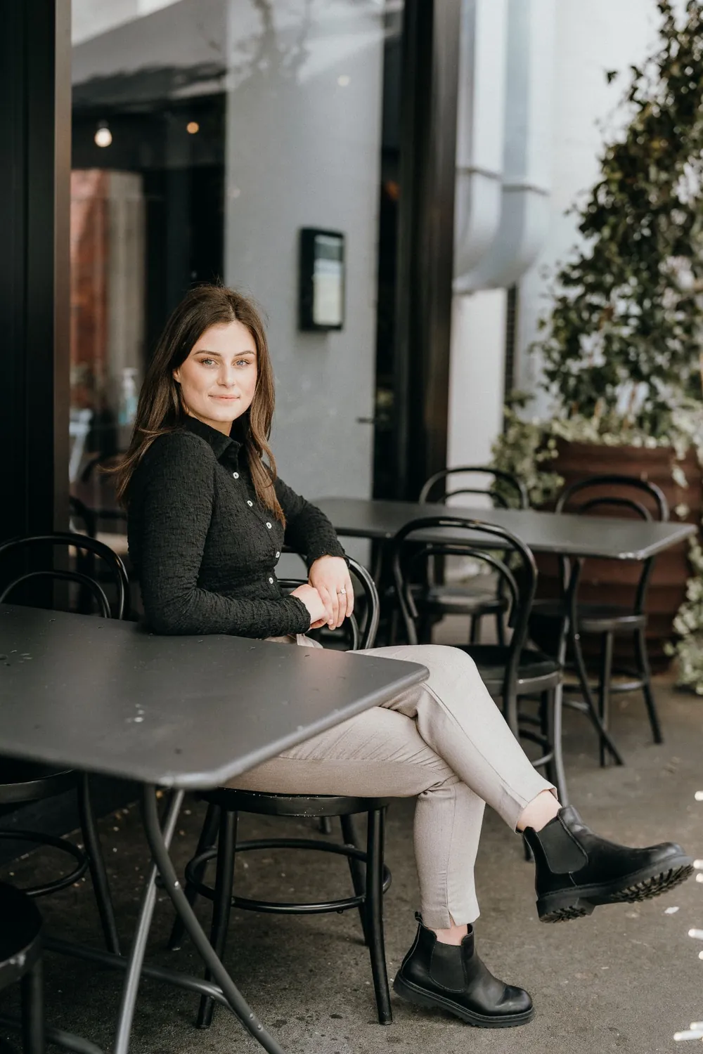 Taylor Bignall, founder of E-assist, seated at a café table